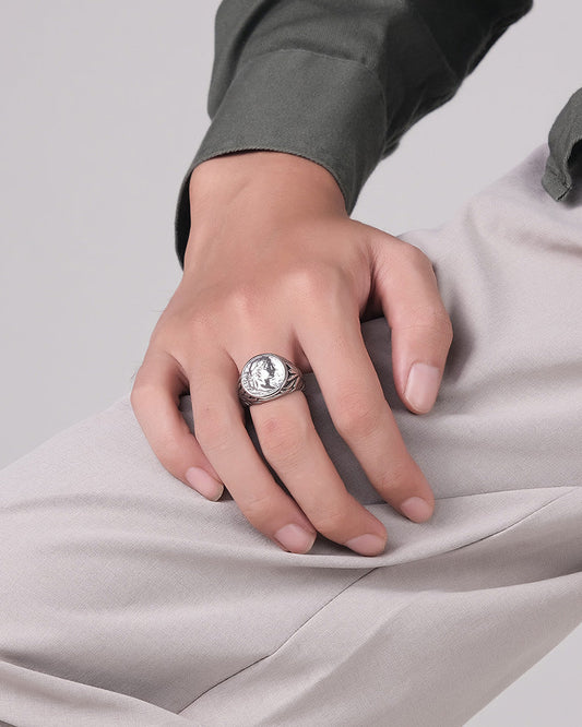 Hand wearing a ring on a light gray background