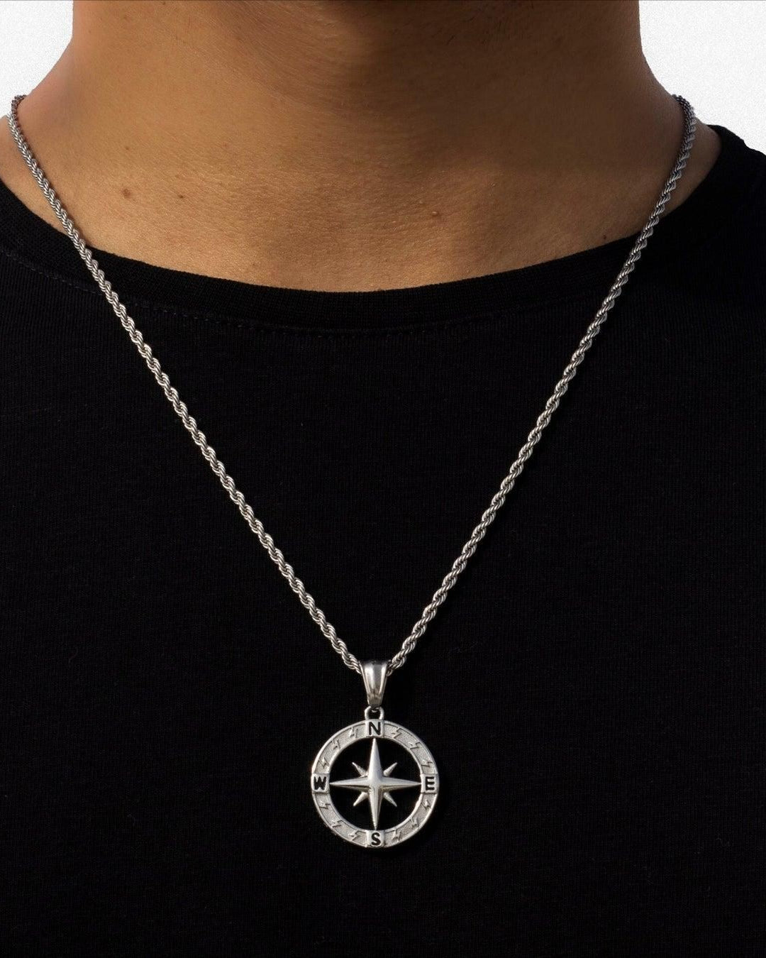 Silver compass necklace on a black shirt