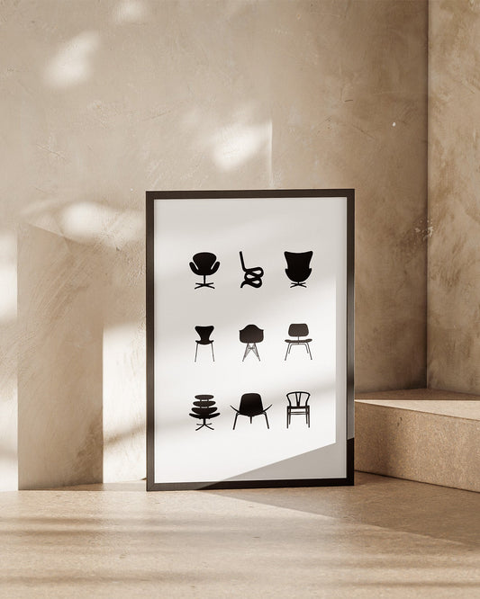 Framed poster with black and white illustrations of iconic eames chairs on a beige wall.