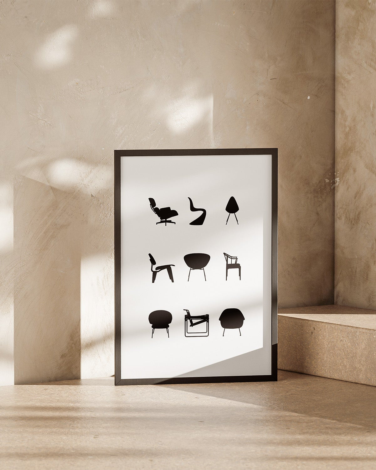 Framed poster with black and white illustrations of iconic chairs on a beige wall.