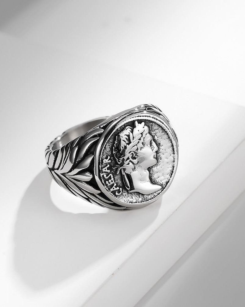 Silver ring with coin design on a white surface